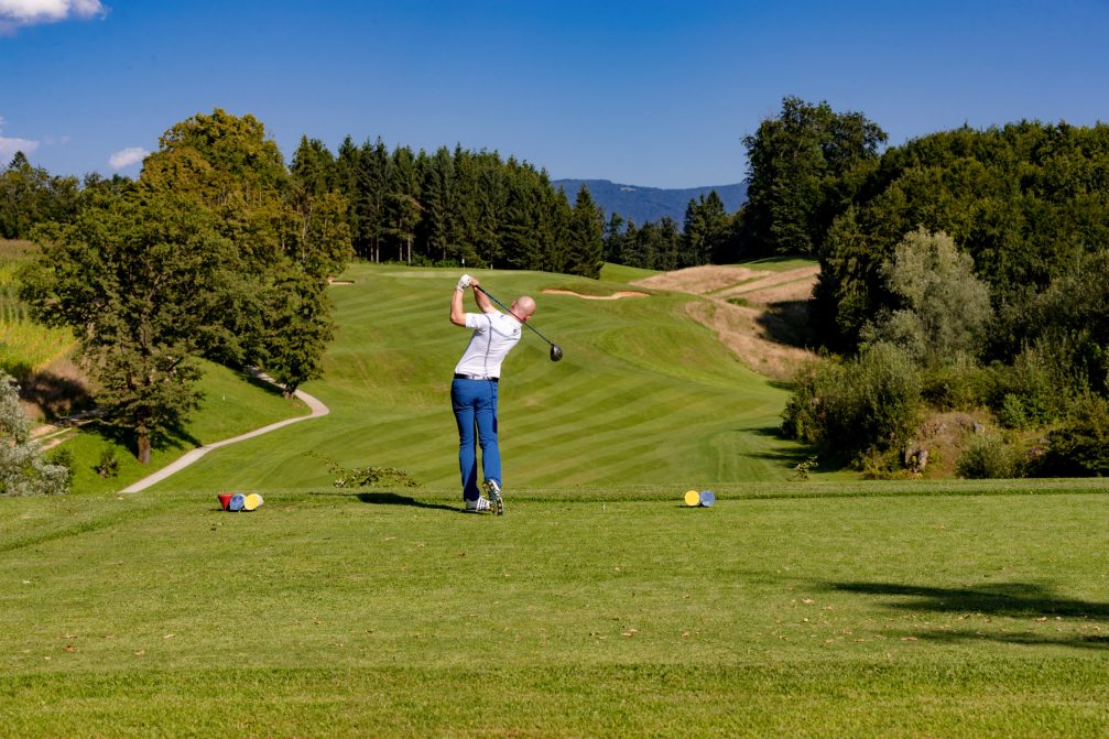 Male golfer teeing off at Otocec Golf Course in Slovenia