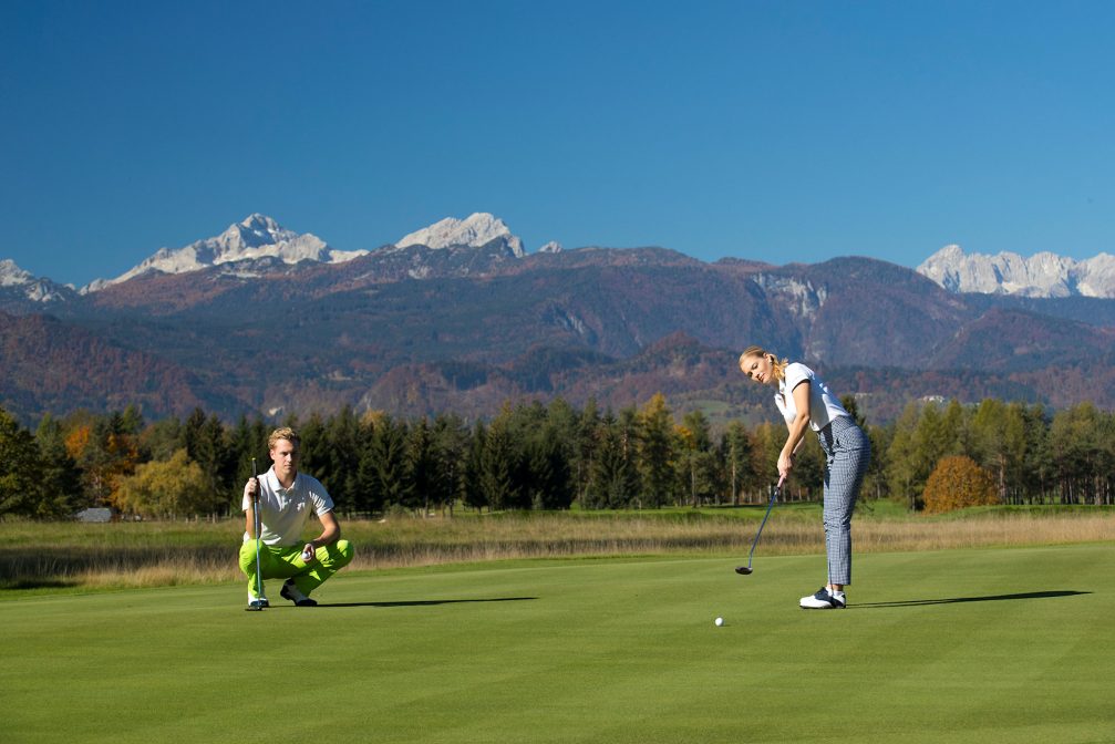 Female golfer putting on the green at Kings Course at Royal Bled Golf in Slovenia