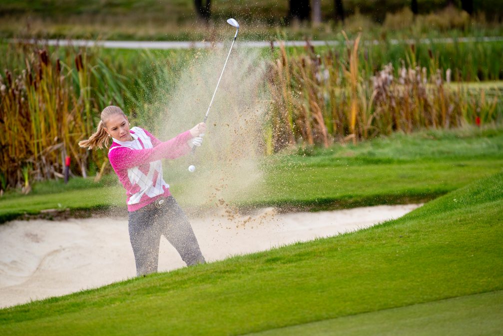 A female golfer at a sand bunker at Kings Course at Royal Bled Golf in Slovenia