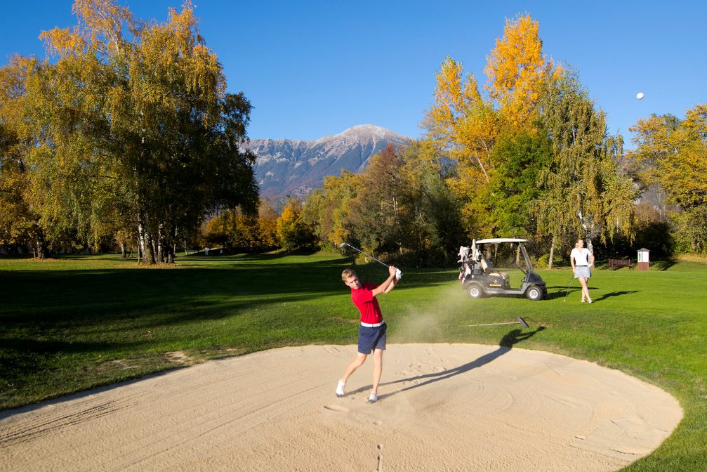 A male golfer at a sand bunker at Kings Course at Royal Bled Golf in autumn