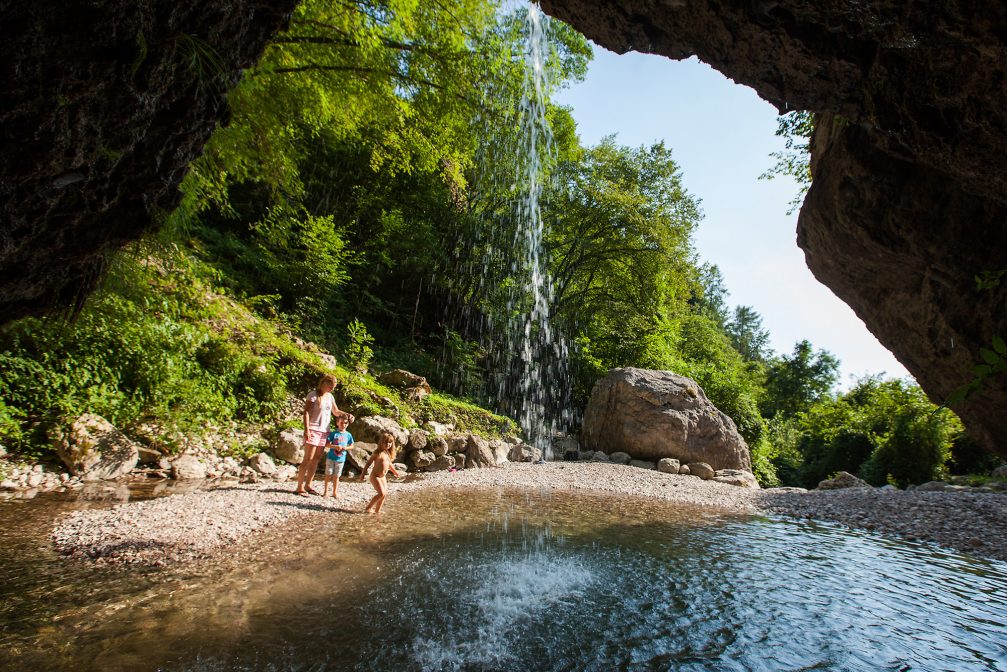 A family swimming in the pool at Krampez waterfall, Slovenia