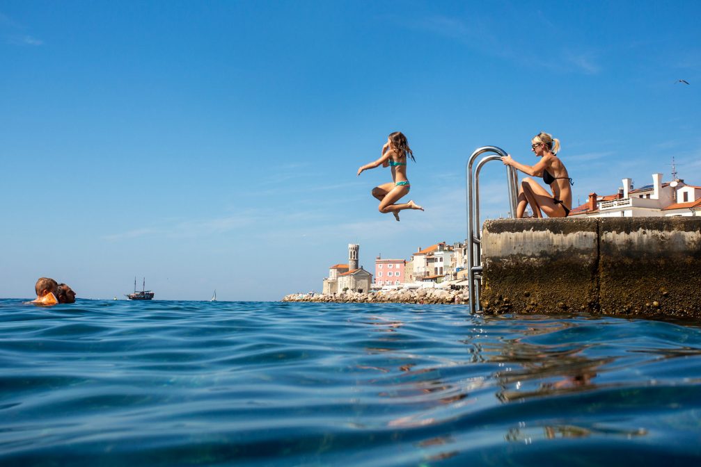 A group of people swimming in the Adriatic Sea in Piran, Slovenia