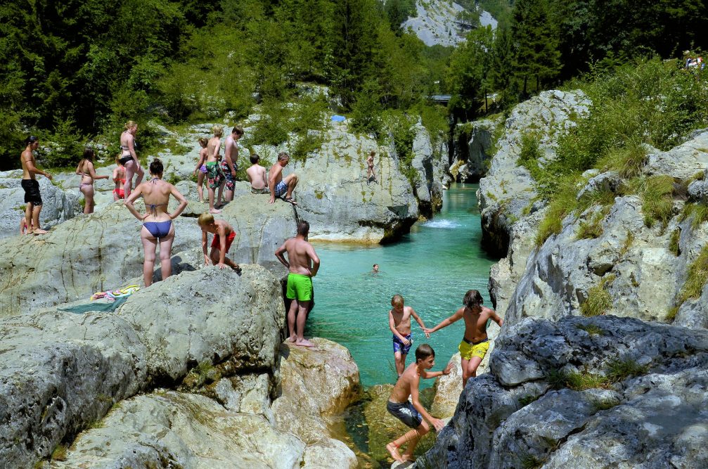 Locals and visitors in Trenta Valley swimming and sunbathing in the Soca river