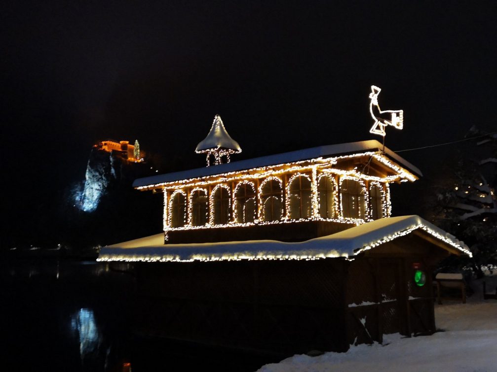 Christmas light displays at Lake Bled with Bled Castle in the background