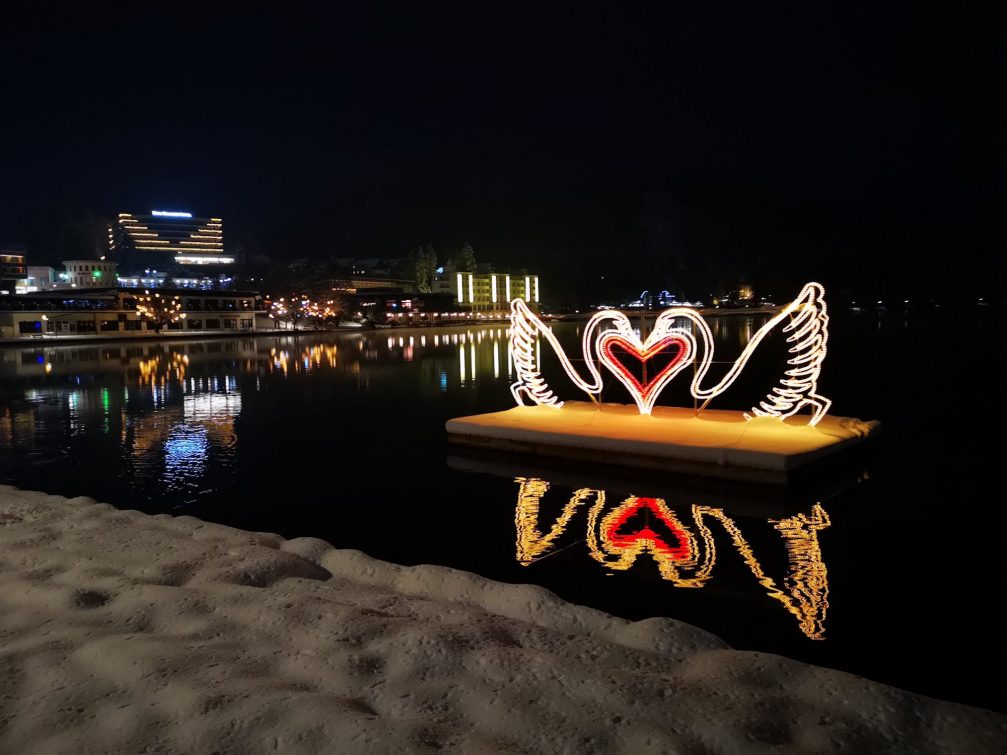 View of Lake Bled and the town of Bled decorated with Christmas Lights in the holiday season