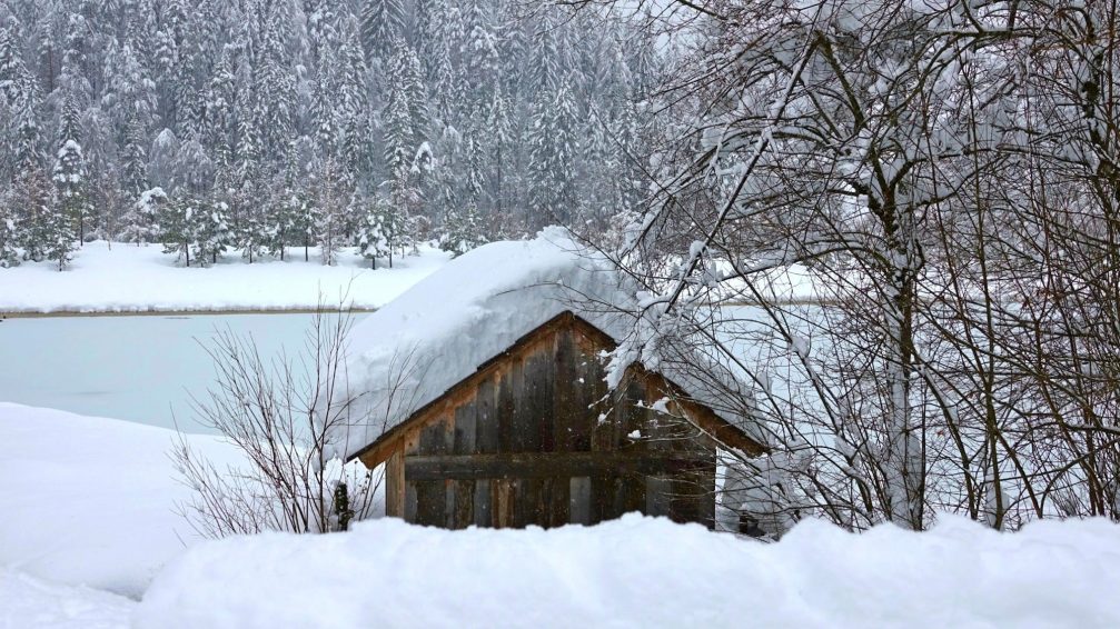 A hut covered in snow at frozen Lake Jasna in winter