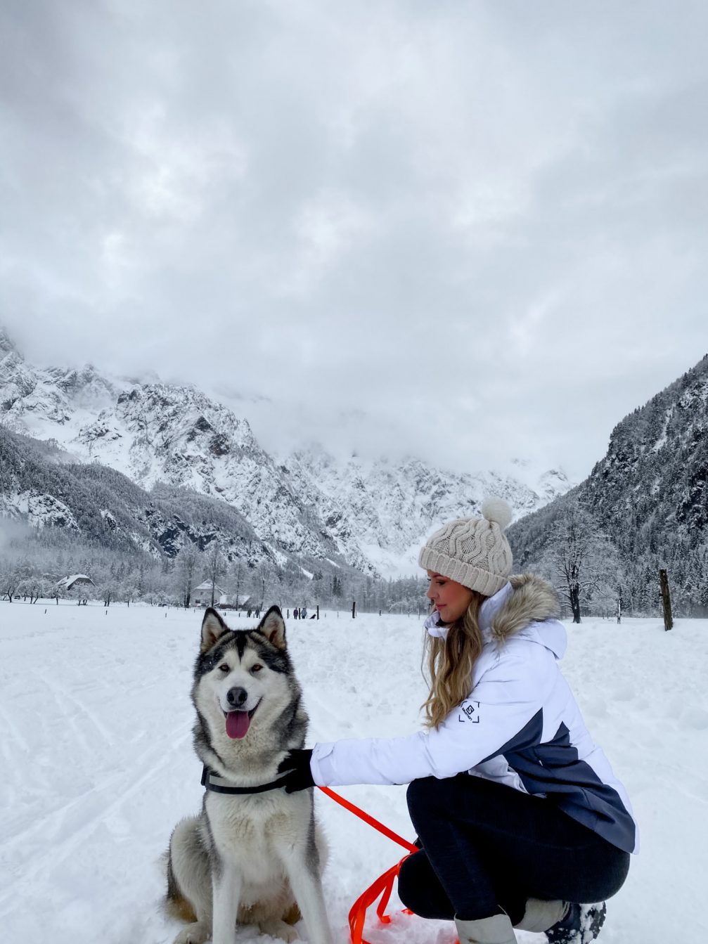 Klavdija Caks with her dog in the snow covered Logarska Valley in winter