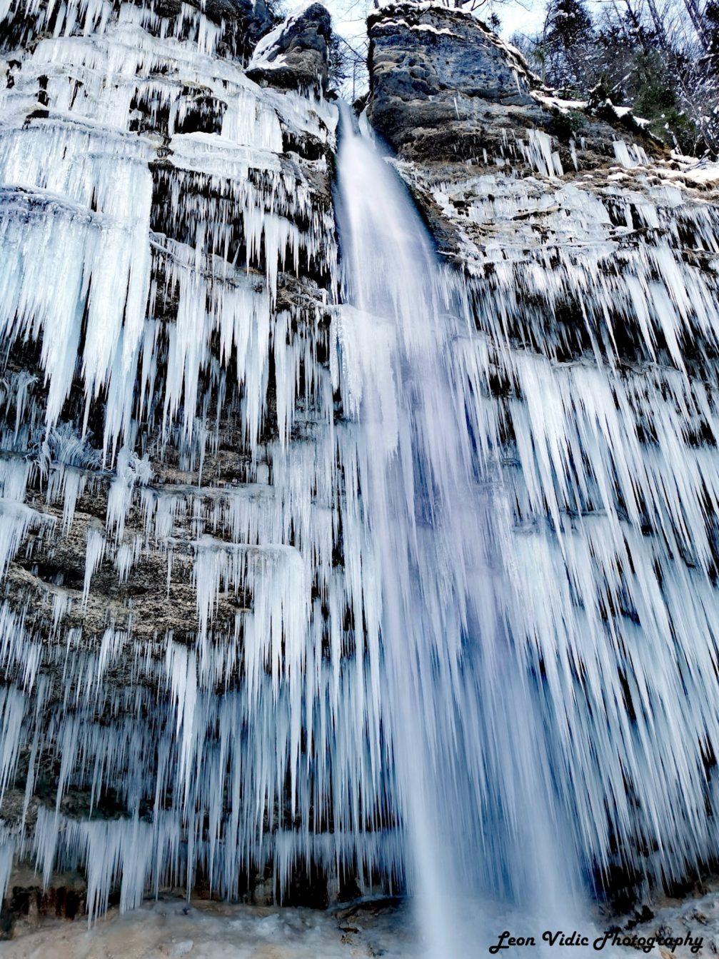 Pericnik Waterfall frozen over and covered in snow in winter