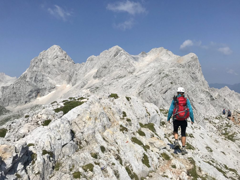 A hiker beneath Mt. Skuta and Mt. Struca in Kamnik-Savinja Alps