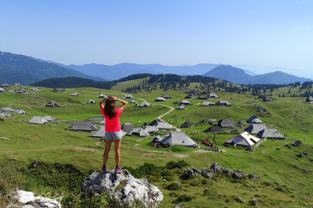 A female hiker looking towards Velika Planina in Kamnik-Savinja Alps