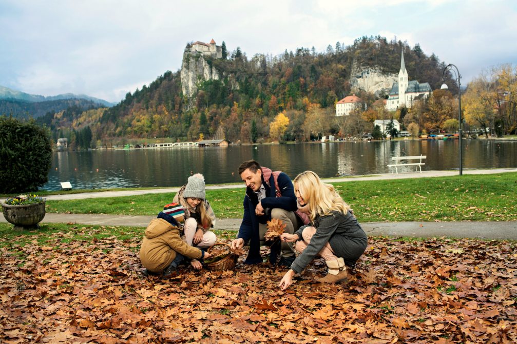 A family at Lake Bled in the autumn with Bled Castle in the background