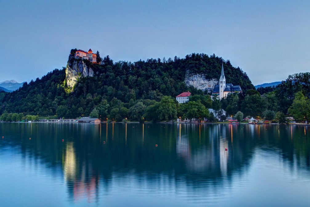 Lake Bled on a summer evening with Bled Castle atop a cliff above the lake