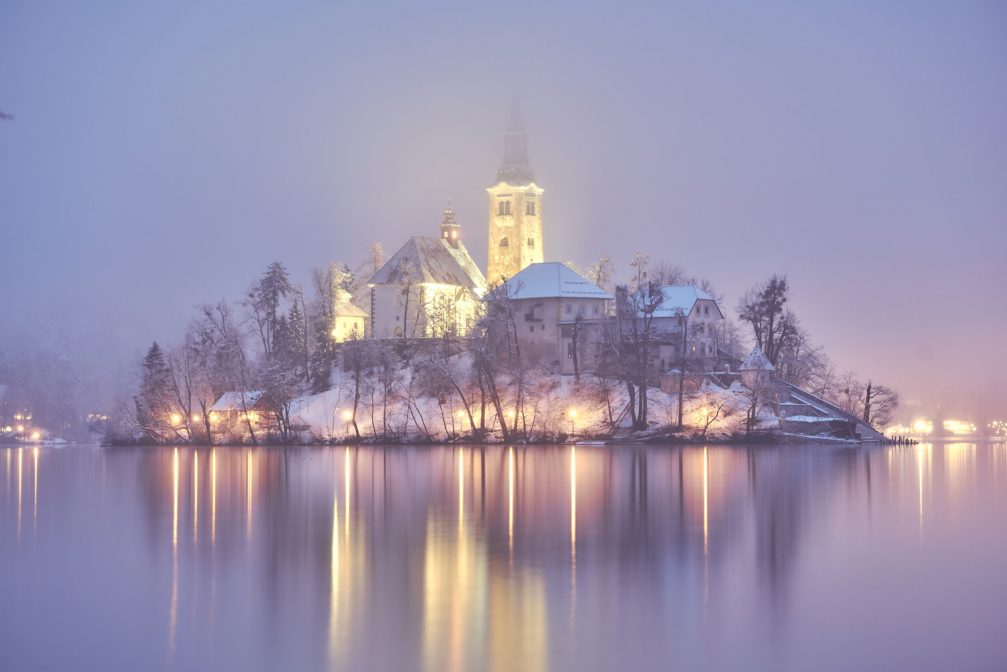 Church on Bled Island lit up at night in the winter