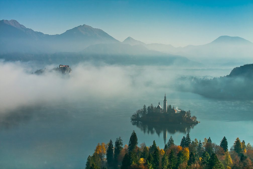 Lake Bled in the fall season with mountains in the background