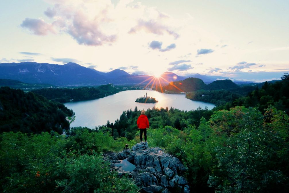 A hiker at Ojstrica Viewpoint with Lake Bled in the background