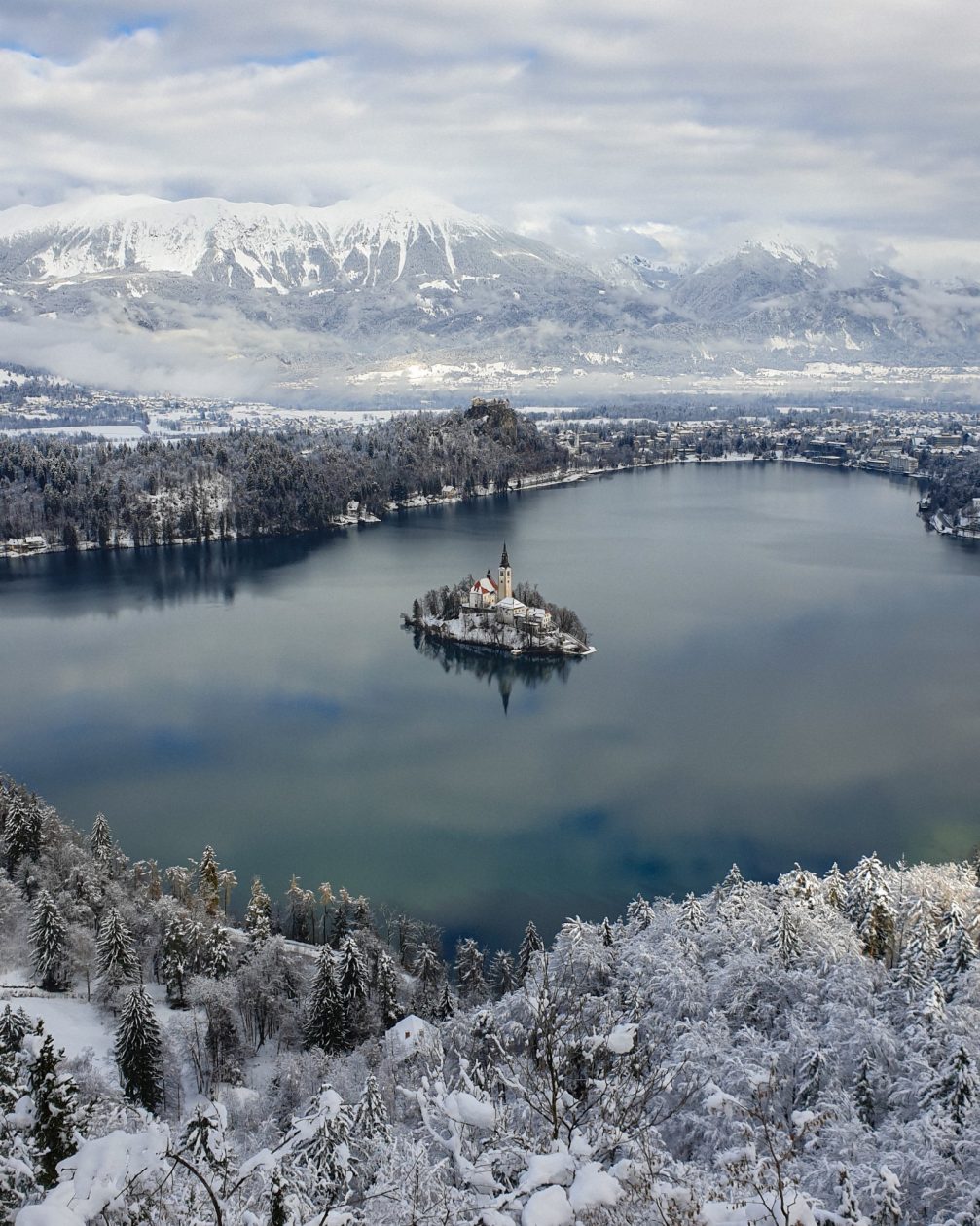 View of Lake Bled with its island with a church and clifftop castle in winter