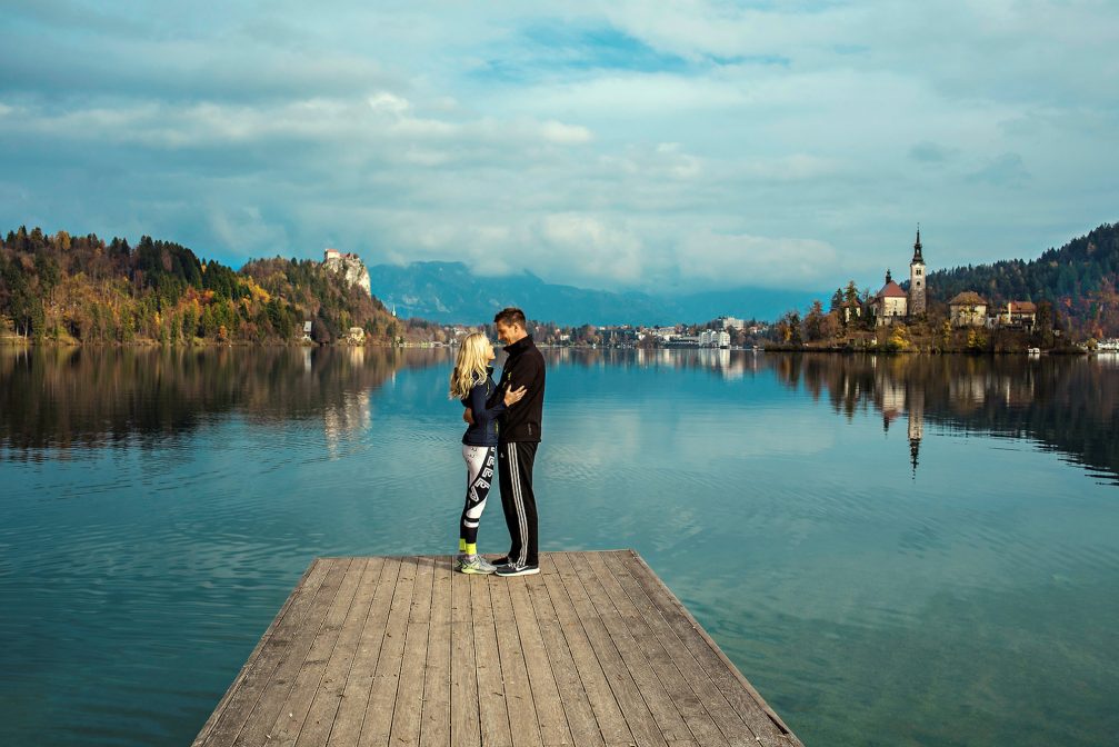 A couple standing on a wooden pier at Lake Bled in Slovenia