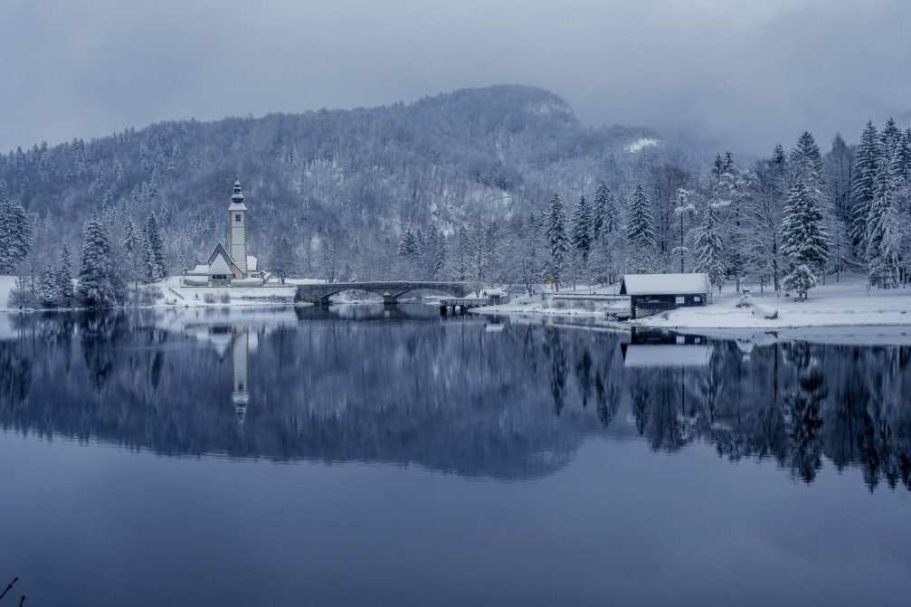 Lake Bohinj and a church covered in snow the next day after snowfall