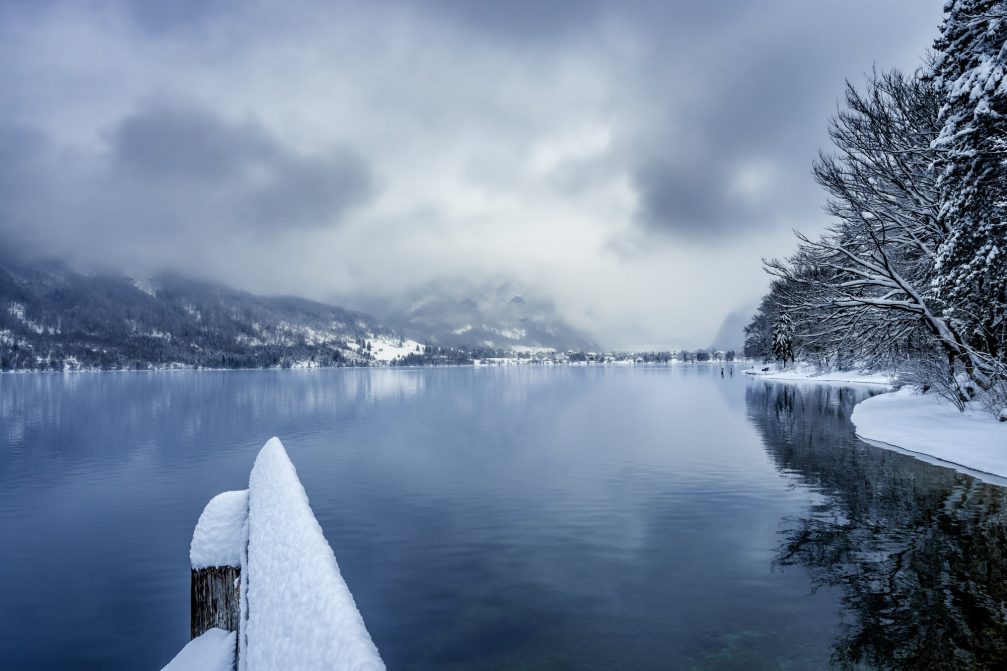 Lake Bohinj covered in snow on a dull day in winter