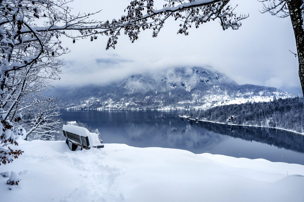 Aerial view of Lake Bohinj covered in snow the next day after snowfall