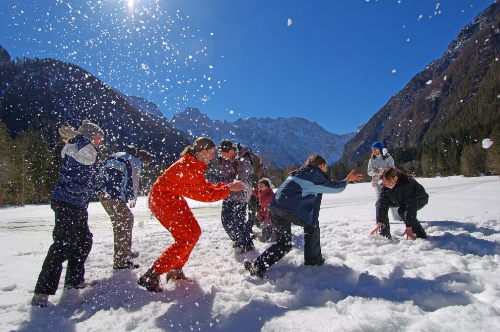 A family playing on the snow in Logarska Valley in winter