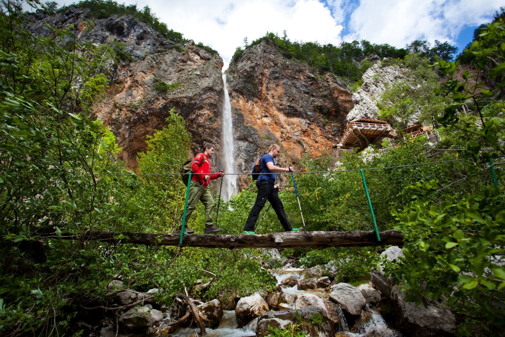 Hikers at Rinka Waterfall in Logarska Valley in Slovenia