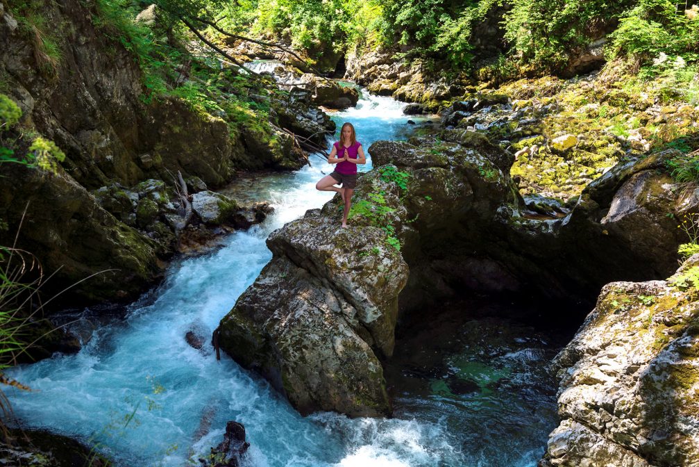 A female practicing yoga in Vintgar Gorge in Slovenia