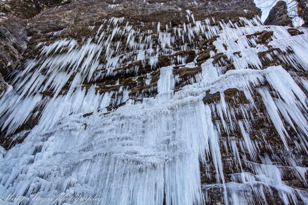 View of the wall of icicles behind Waterfall Pericnik in Triglav National Park in winter