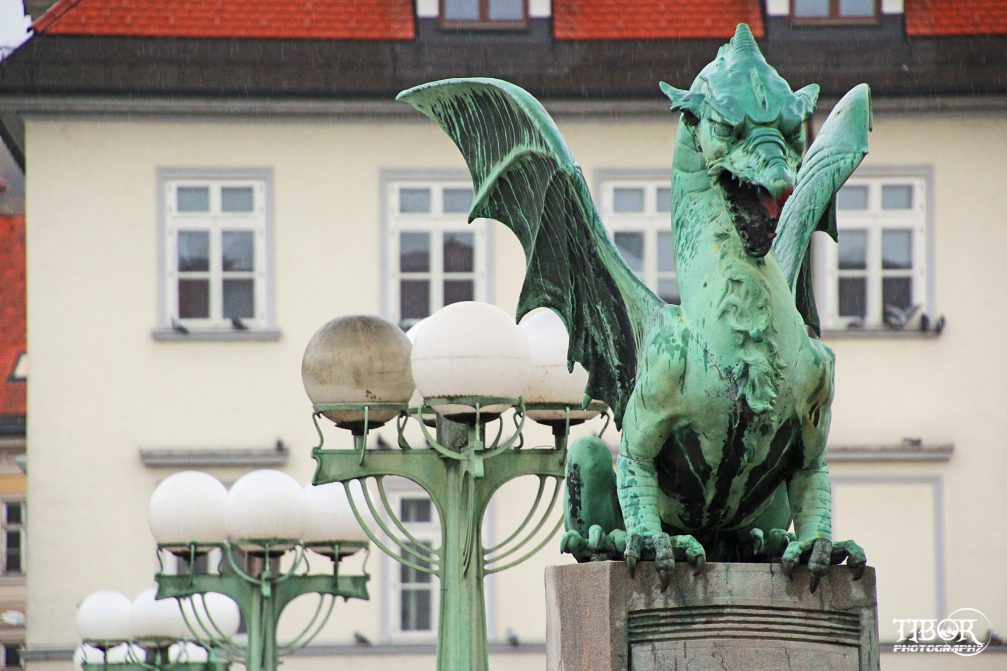 A huge, scary-looking dragon and parapet lamps on Dragon Bridge in Ljubljana