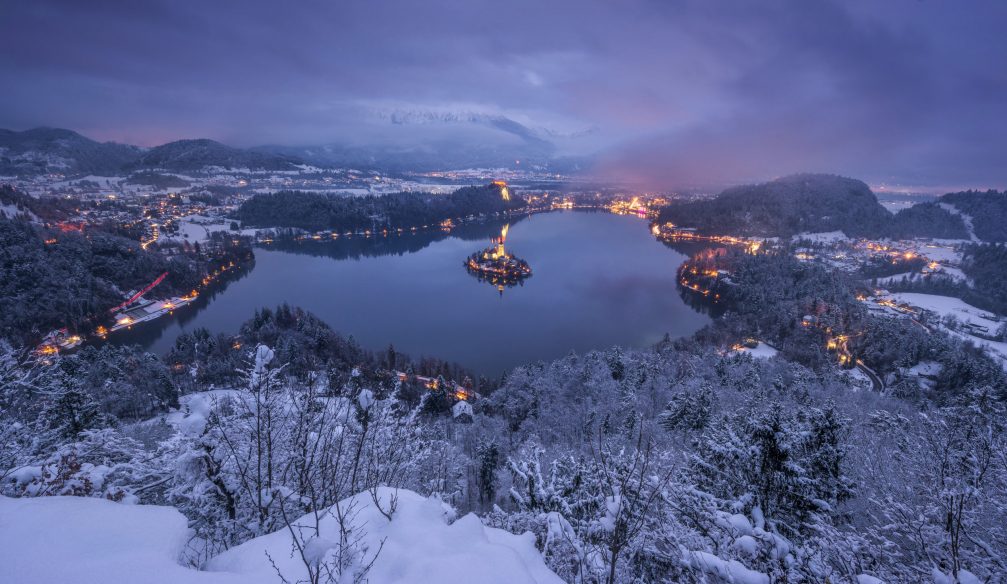 Lake Bled on winter evening with the area covered in snow