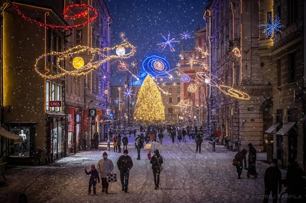 Slovenia's capital Ljubljana covered in snow at night with Christmas Tree in the background