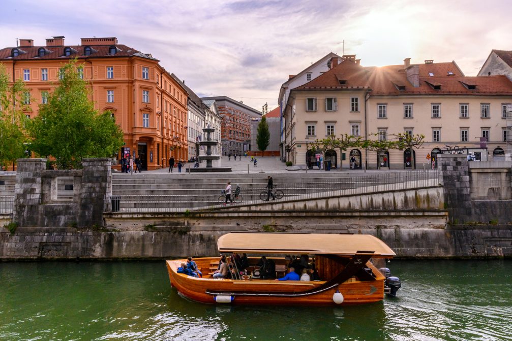 A wooden tourist boat on the Ljubljanica river in Ljubljana Old Town