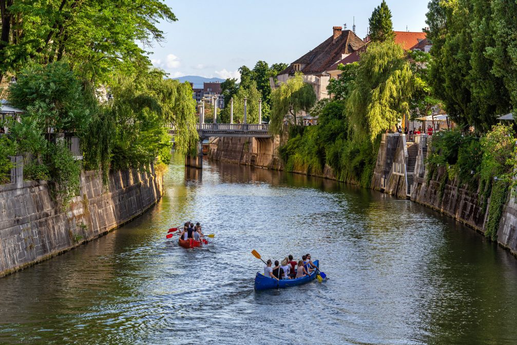 Ljubljanica River in Ljubljana with two canoes with tourists