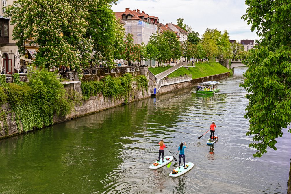 Stand up paddle boarders on Ljubljanica River in Ljubljana Old Town