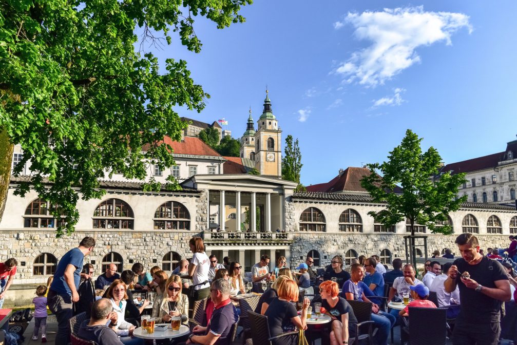 People at the Petkovskovo Embankment with the Ljubljana Cathedral in the background