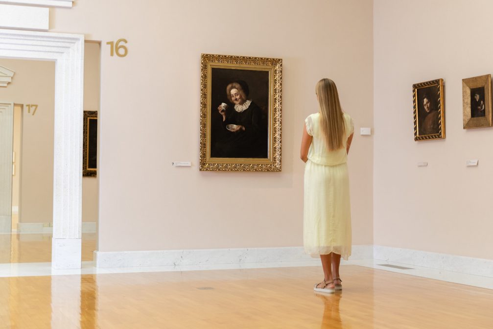 A female visitor watching the Coffee Drinker painting by Ivana Kobilca in National Gallery Of Slovenia in Ljubljana