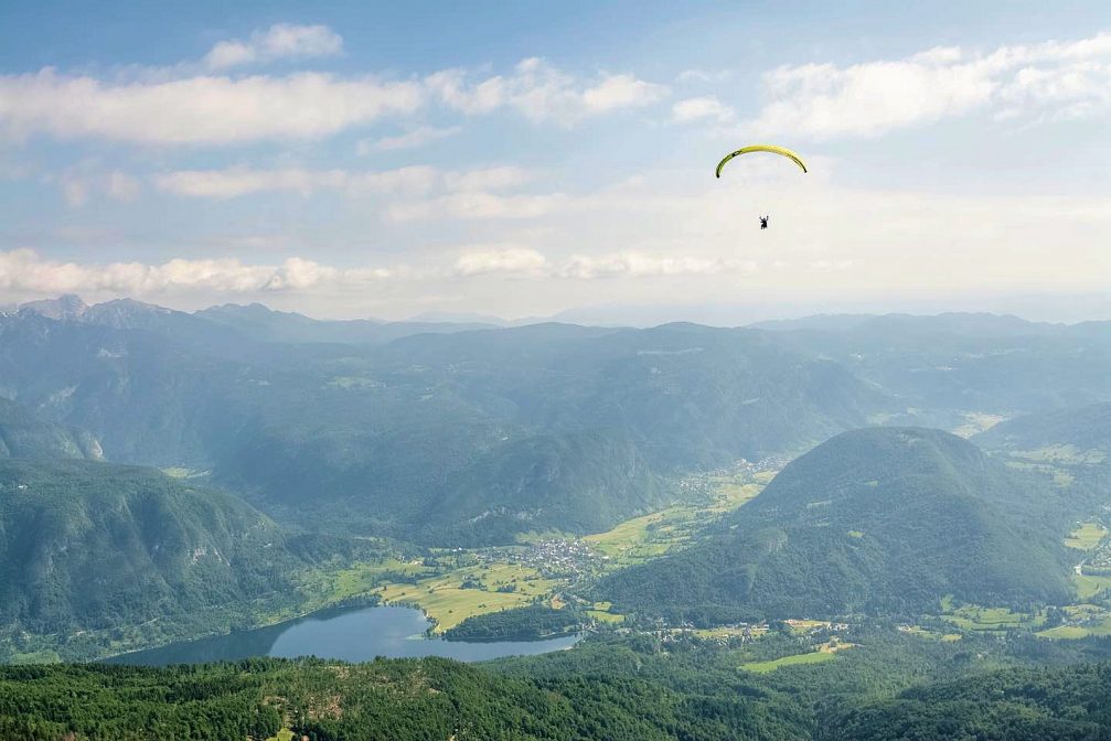 Paragliders over Lake Bohinj with Julian Alps in the background