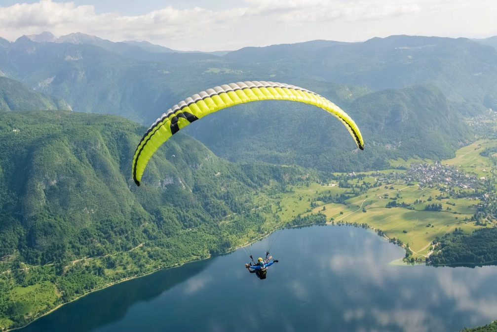 Tandem paragliders above Lake Bohinj in Slovenia, designed to carry the pilot and one passenger