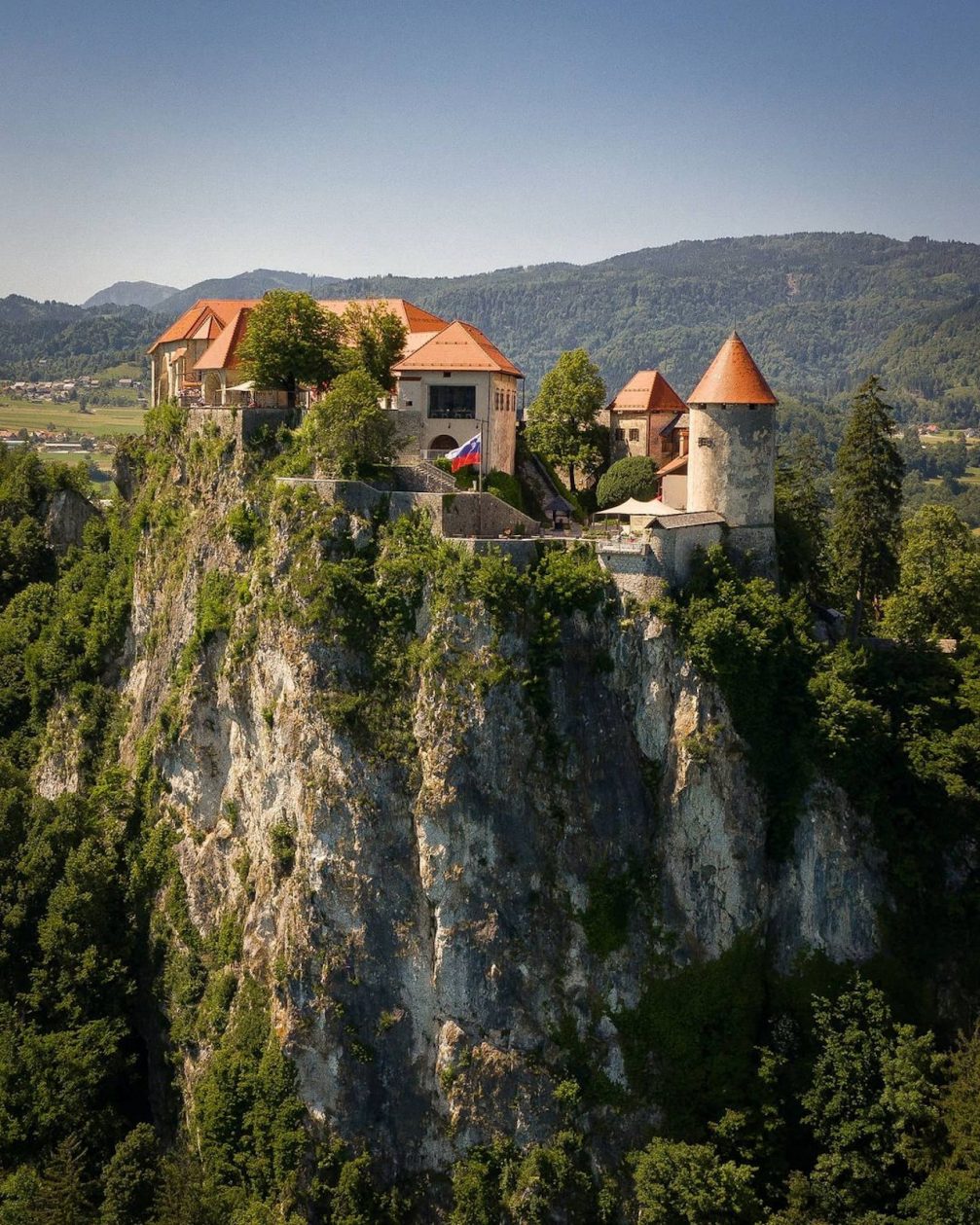 Aerial drone view of Bled Castle on a cliff above Lake Bled in Slovenia