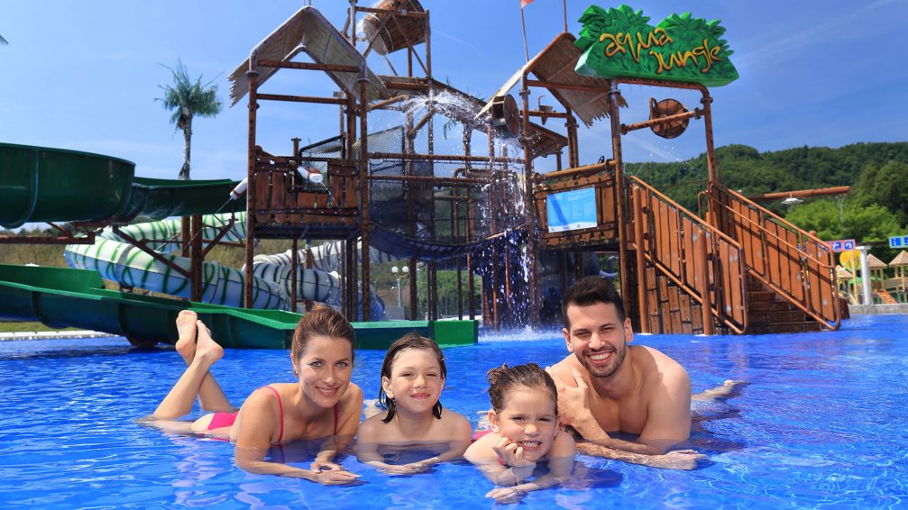 A family posing in front of Aqua Jungle in Thermal Park Aqualuna at Terme Olimia