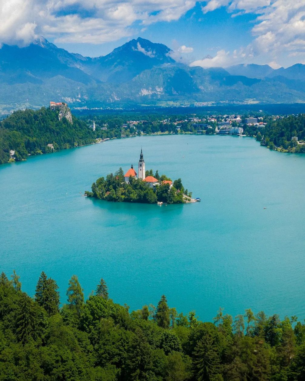 Aerial drone view of Bled Island in the middle of Lake Bled with Karavanke mountains in the background