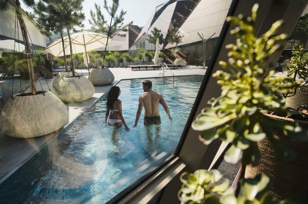 A couple in an outdoor pool at Wellness Orhidelia thermal spa in Terme Olimia in Podcetrtek