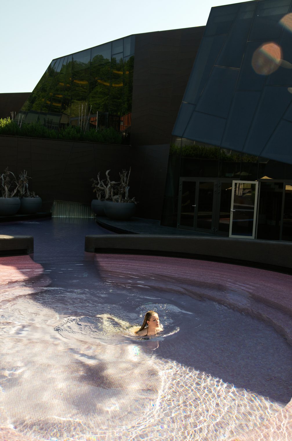 A woman swimming in an outdoor pool at Wellness Orhidelia thermal spa in Terme Olimia in Podcetrtek