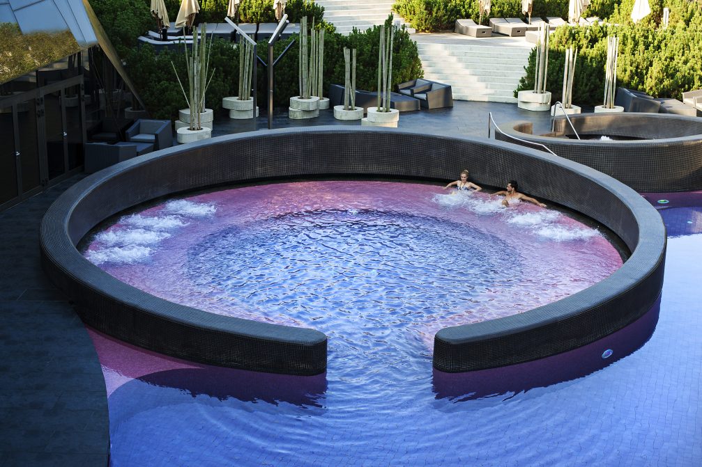 A couple relaxing in an outdoor pool at Wellness Orhidelia thermal spa in Terme Olimia