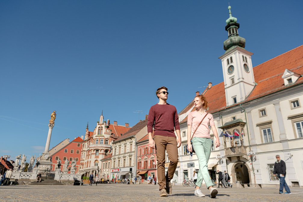 A couple walking through Main Square in Maribor, Slovenia